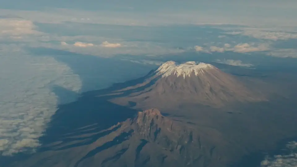 Aerial view of snow-capped mountain kilimanjaro peak above clouds