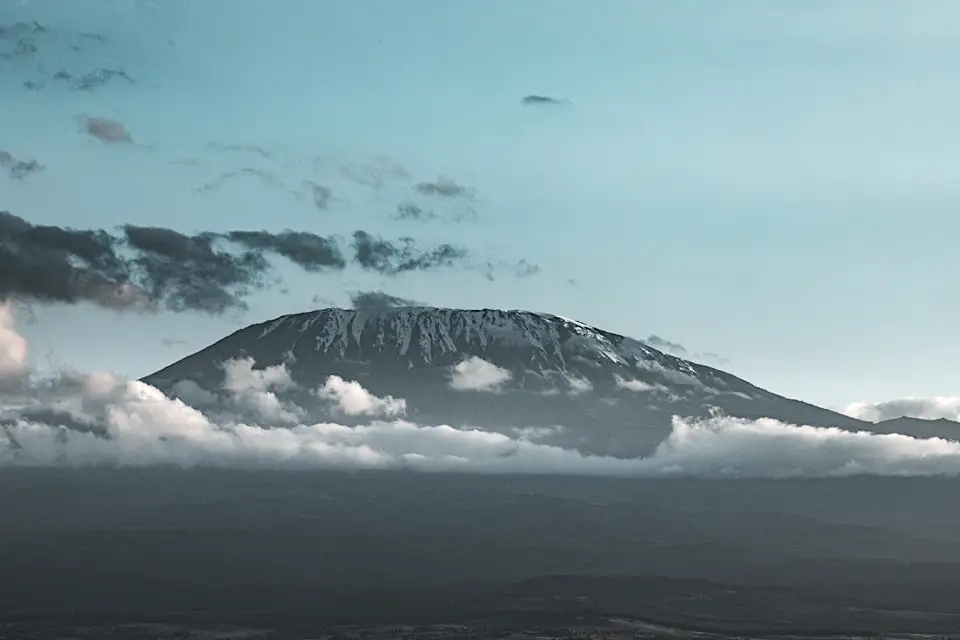 Snow-capped mountain with clouds at twilight